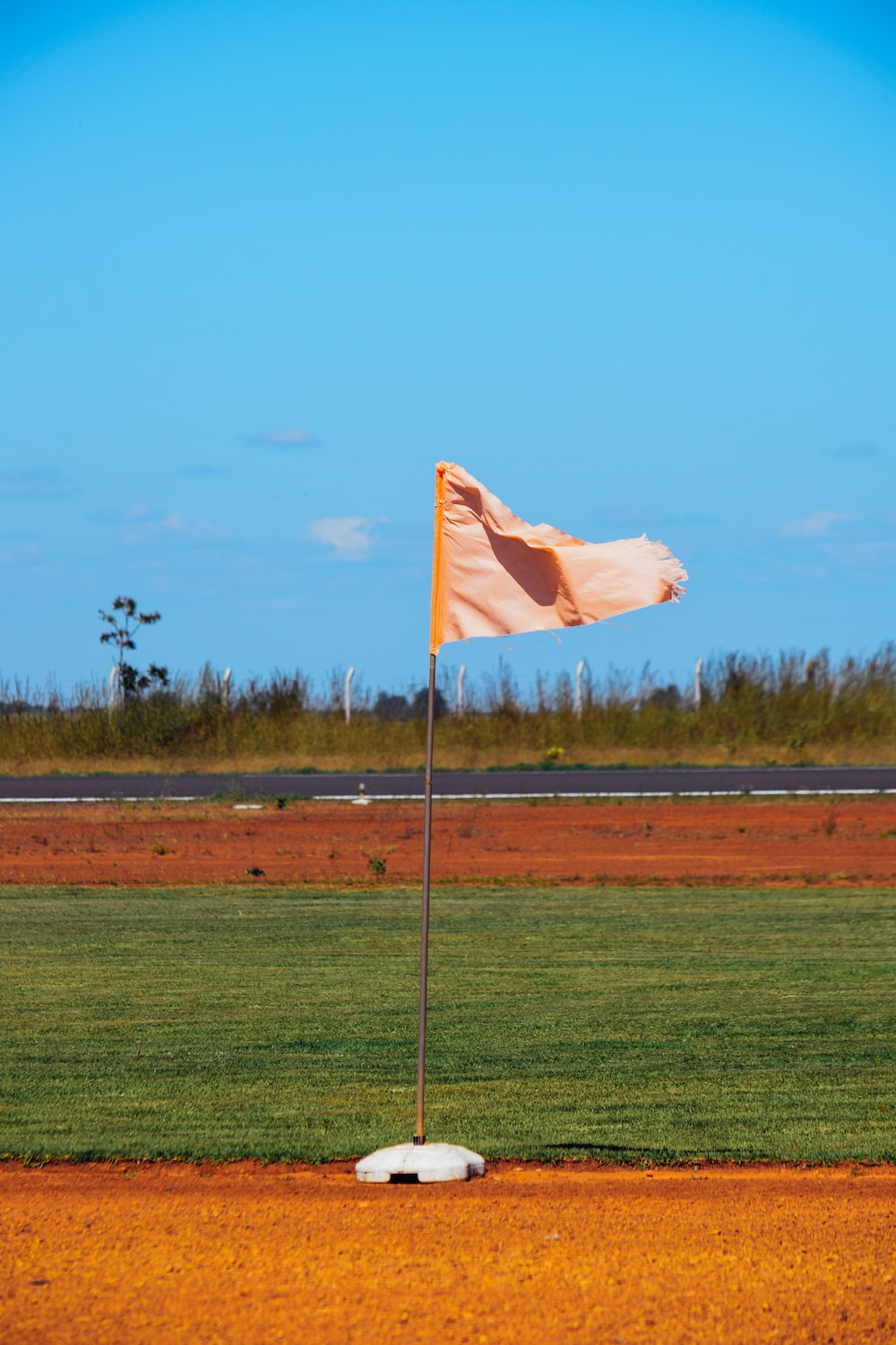 a flag on a baseball field with a dirt base