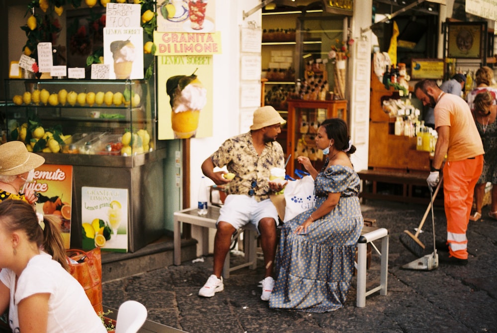 a group of people sitting outside of a store