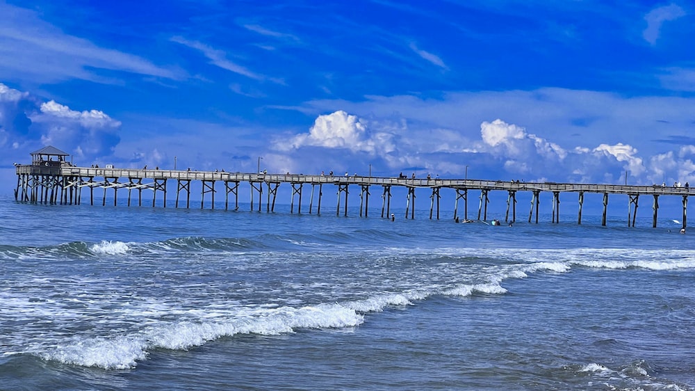 a long pier stretches out into the ocean