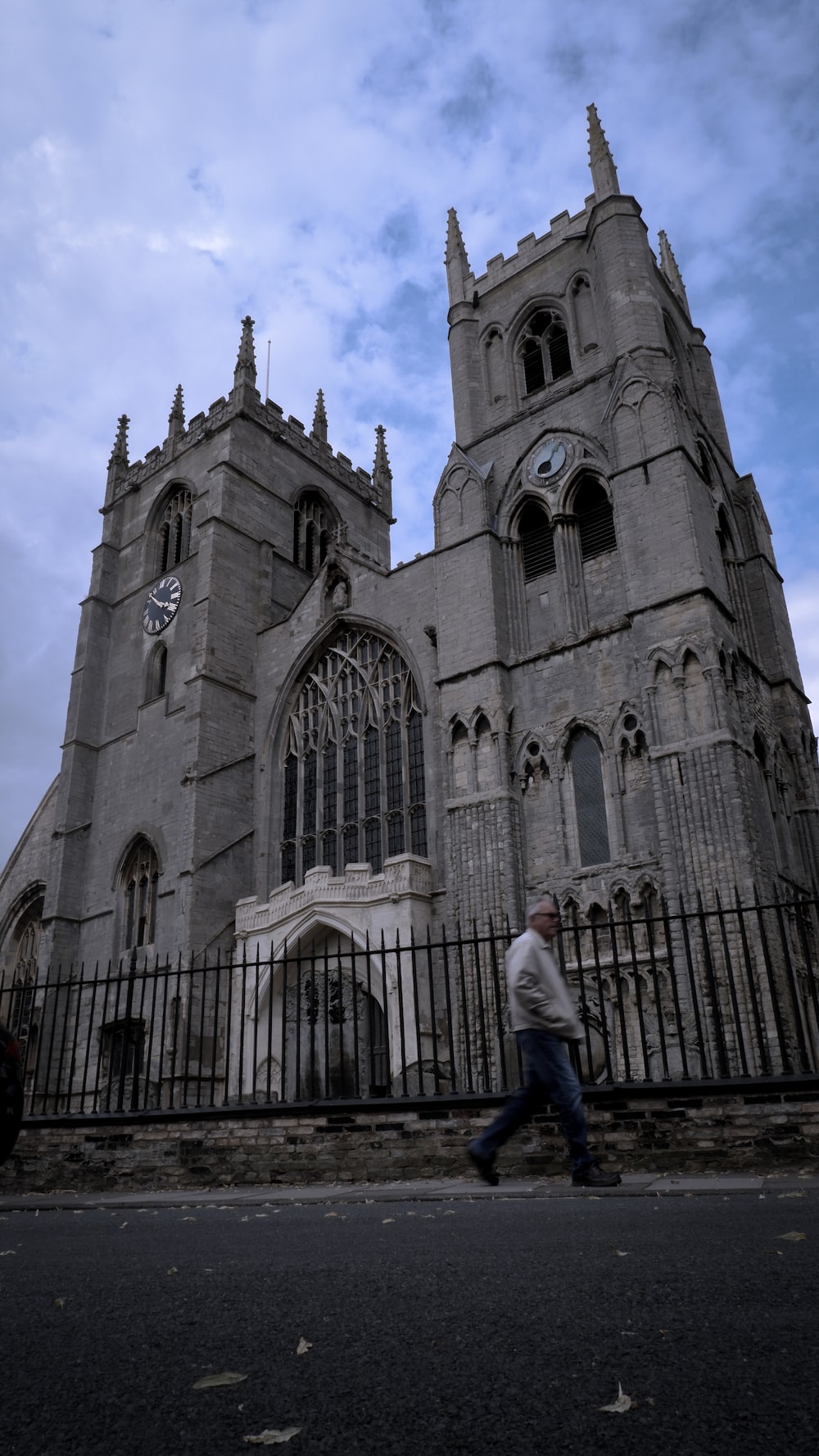 a man walking down a street past a tall building