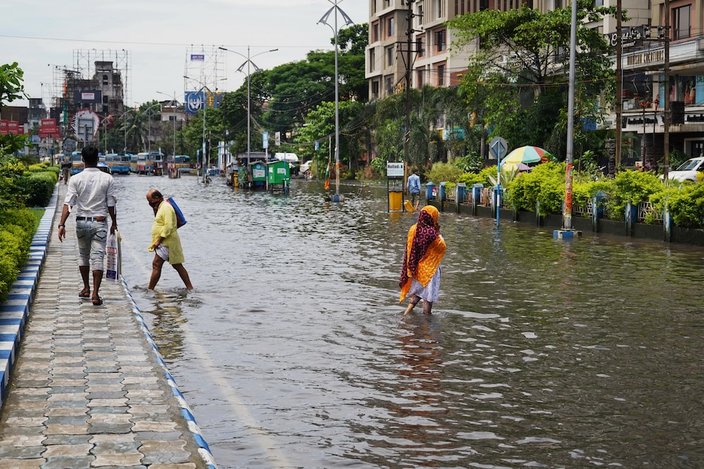 people walking in a flooded street